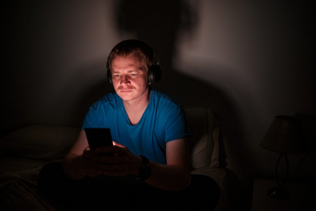 odrasla osoba gleda u mobitel umjesto da spava mobitel